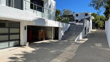 A modern building with a garage, a staircase, and a paved walkway.