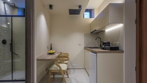 A compact kitchen with a dining area, a built-in oven, and a small refrigerator.