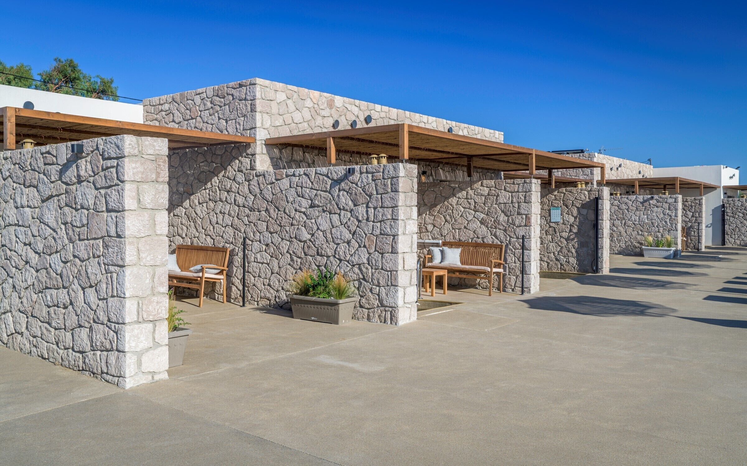A modern building with stone walls and wooden benches.