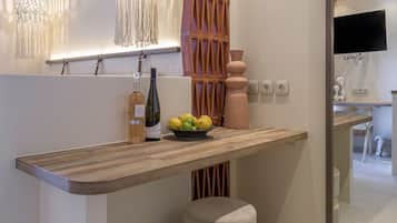 Une cuisine moderne avec des poutres en bois, des luminaires suspendus, un meuble-bar intégré et un petit tabouret.