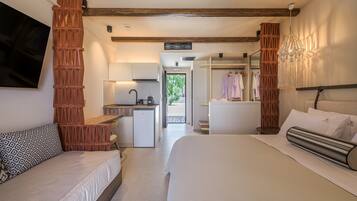 Habitación de hotel con dos camas, kitchenette, baño y vistas al exterior.