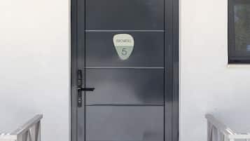 Una puerta negra moderna con un letrero que dice 'PROVINTAS 5' y un picaporte de metal.