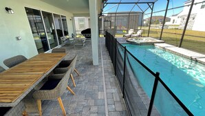 A covered patio with a pool, outdoor furniture, and a view of the surrounding area. - 8957-HiltonRidge (Kissimmee)
