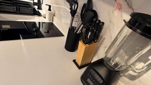 Keittiön työtaso, jossa on tehosekoitin, kahvinkeitin ja veitsiteline.