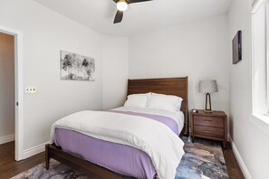 A bedroom with a bed, a nightstand, a lamp, a ceiling fan, and a wall-mounted artwork. - Fairway Oasis • Private Pool, Spa & Putting Green (Chandler)