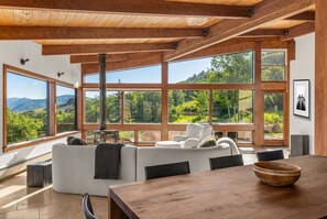 Ein modernes Interieur mit einem großen Holzesstisch, einer Couch und einem Kamin.