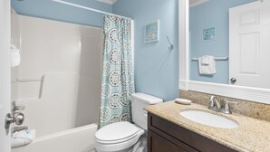 A bathroom with a shower, toilet, sink, and mirror. - Beachside Villas 1023 (Santa Rosa Beach)