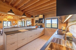 Una cuina moderna amb armaris de fusta, una illa gran i vistes a l'exterior.