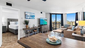 Un salon moderne comprenant un coin repas, un lit, un téléviseur et un balcon avec vue.