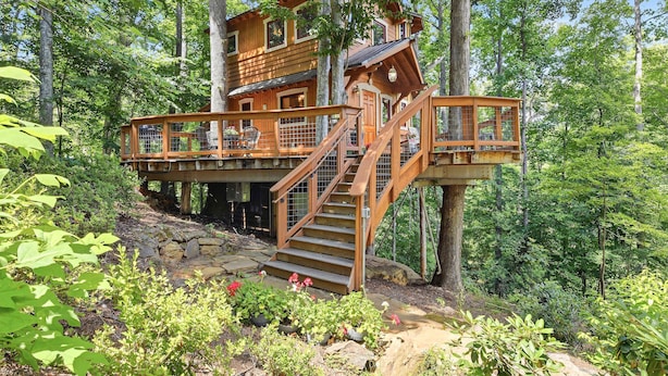 A wooden treehouse with a balcony and stairs. - Luxury Treehouse, gas fireplace, BBQ, firepit, outdoor dining, shared creek access (Weaverville)