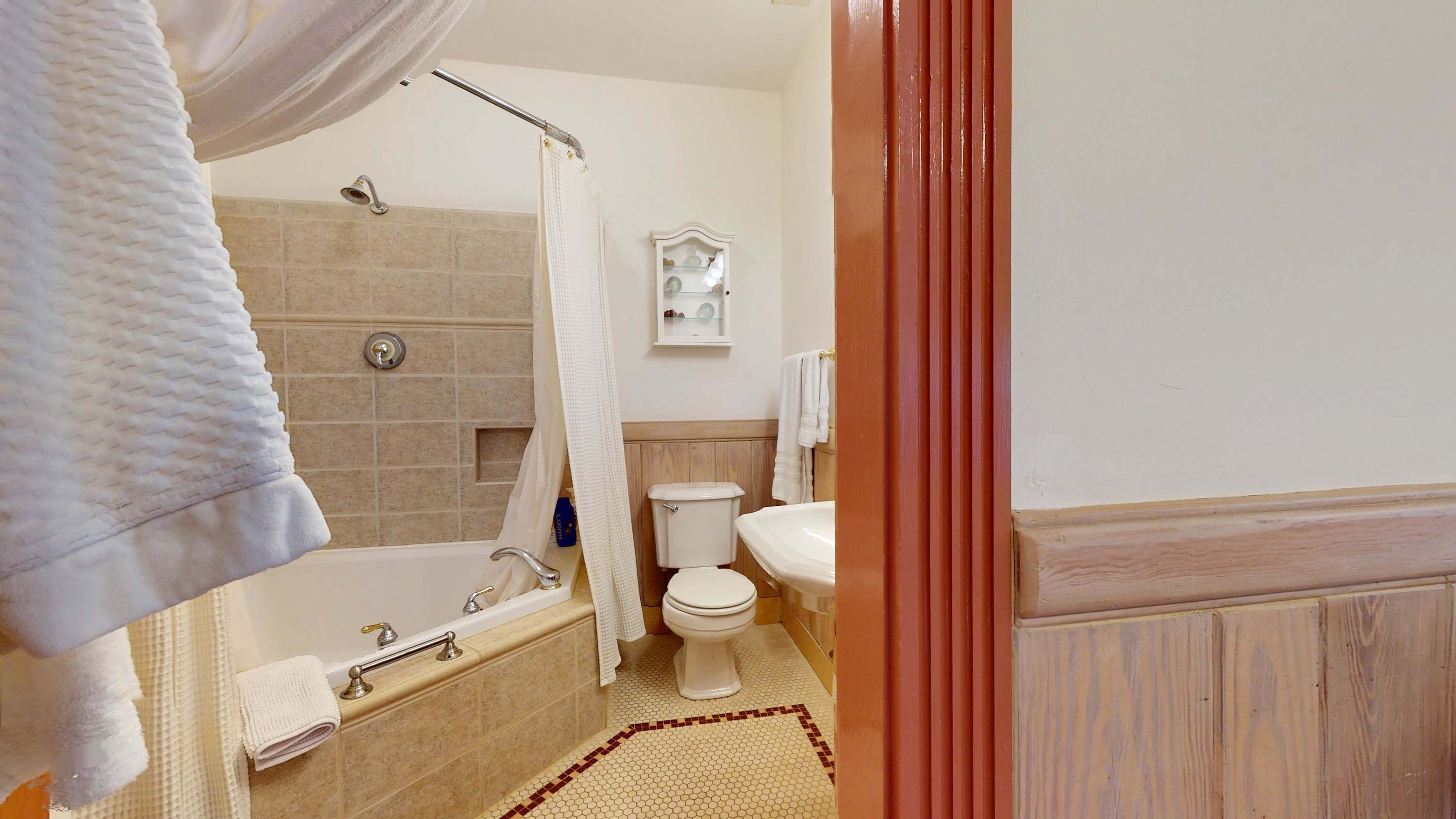 Une salle de bain équipée d’une baignoire, d’une douche, de toilettes et d’un lavabo.