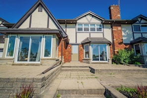 A two-story house with a front entrance, a brick chimney, and a small front garden. - The Parkway Boutique Hotel by the Falls (Niagara Falls)