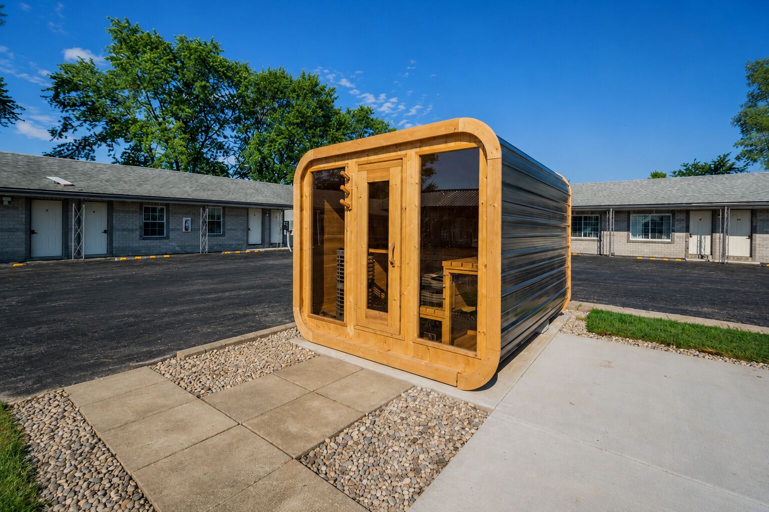 A single-story building with a large wooden structure in the foreground, likely a sauna or steam room, with a clear view of the parking lot and adjacent buildings in the background.
