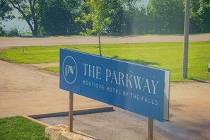 Schild für das 'The Parkway Boutique Hotel by the Falls' mit Blick auf eine Straße und Grünflächen.