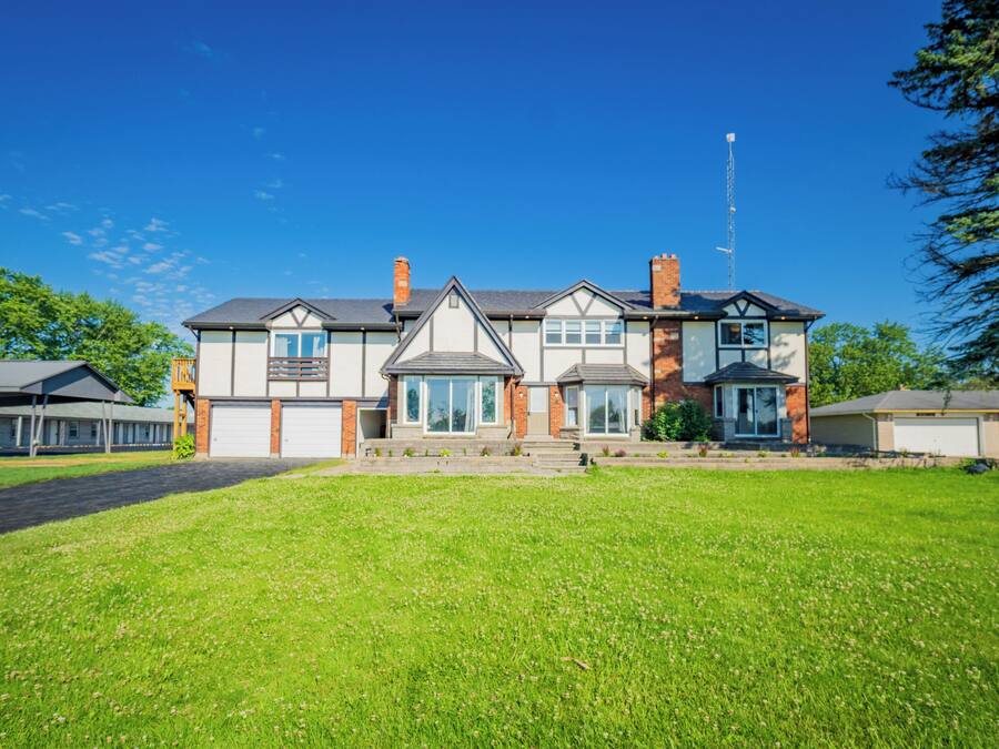 A two-story house with a front lawn, a garage, and a satellite dish.