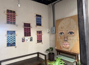 Una habitación con un muro decorado con tapices estampados y un cuadro abstracto grande.