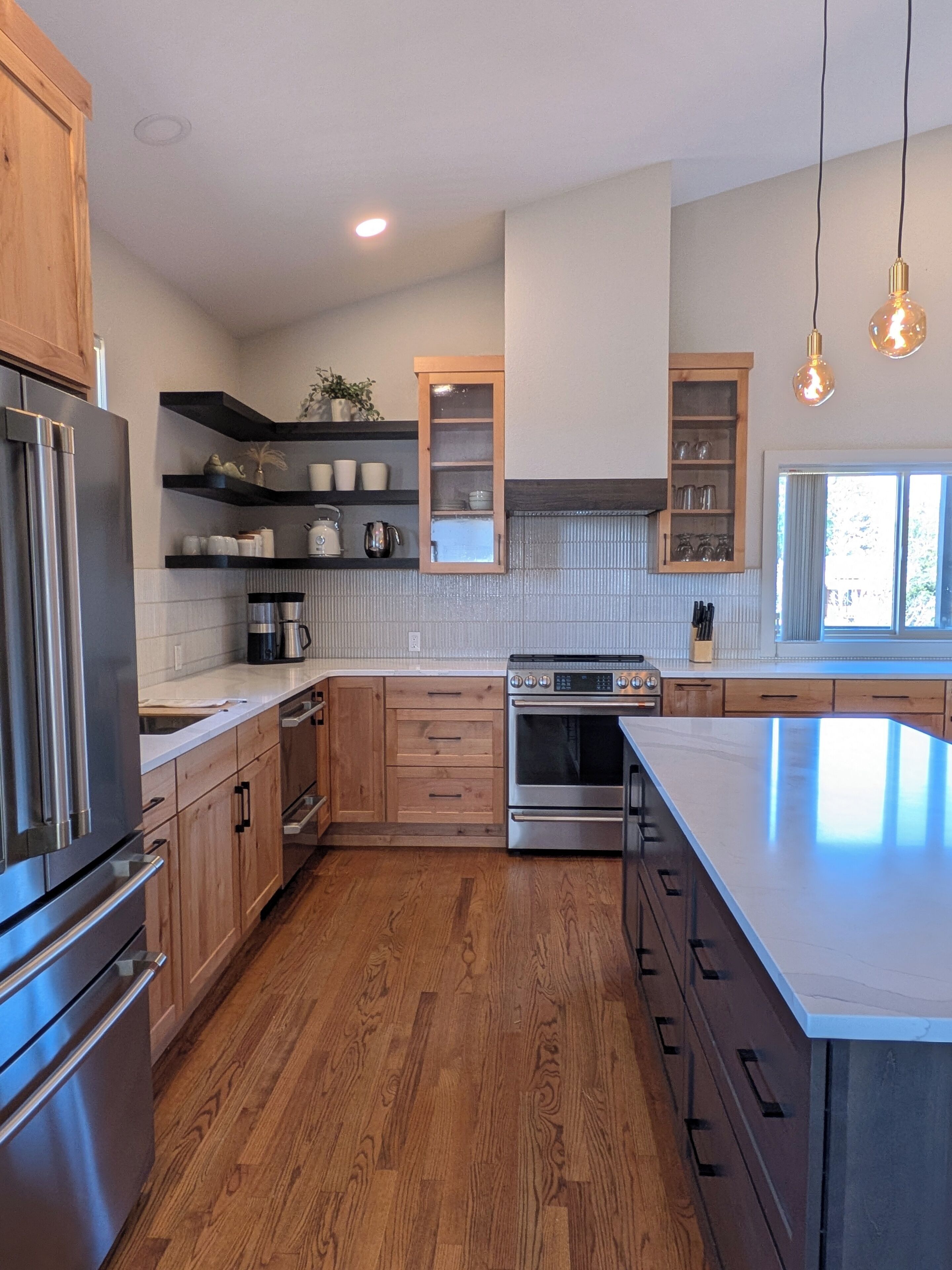 A modern kitchen with wooden cabinets, stainless steel appliances, and a large island.