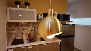 A kitchen with a hanging pendant light, a microwave, and a refrigerator. - 1.7 • Balcony • Generator • Parking • 2nd Floor (Mayagüez)