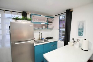 Cafetera o tetera, frigorífico, microondas y placa de cocina