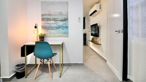 Una habitación moderna con escritorio, silla y un cuadro en la pared.
