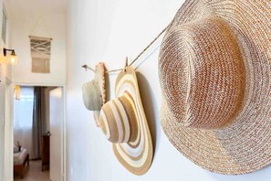 A room with a large woven hat hanging on the wall, a woven wall hanging, and a wooden object. - 3.7 Near Beach • Generator • Hammock • 2nd floor (Miradero)
