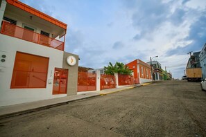 Vista de la calle con edificios, un reloj y un camión estacionado.