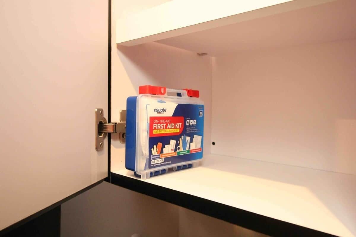 A storage cabinet with a blue and white first aid kit labeled 'equate' on the door.