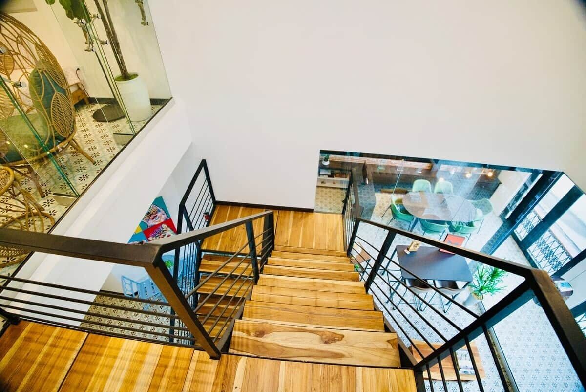 A wooden staircase with metal railings leading to an upper floor.
