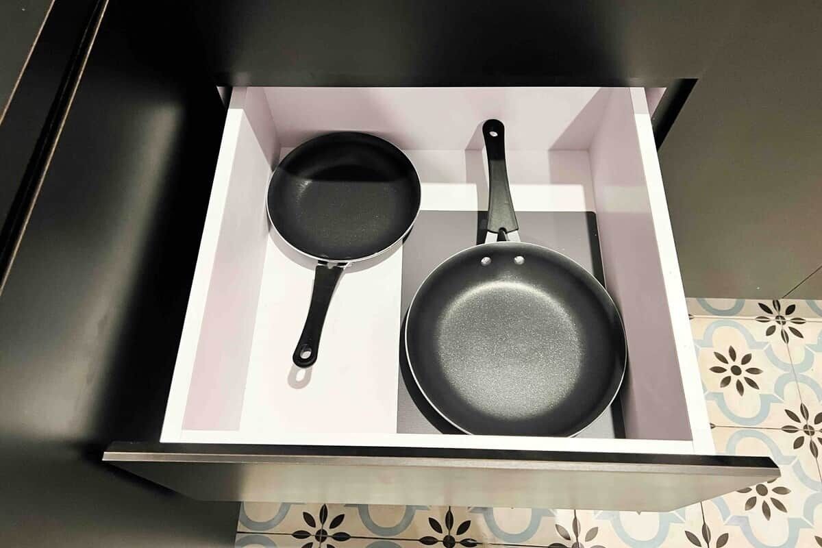 A drawer with two frying pans.