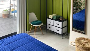 A bedroom with a bed, a chair, a dresser, a plant, and a window. - Very Private Shared Room with Private Bathroom and Terrace (Ciudad de México)