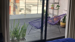 A balcony with a view of buildings, a purple chair, and a plant. - Very Private Shared Room with Private Bathroom and Terrace (Ciudad de México)
