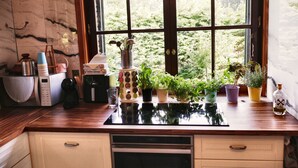 A kitchen with a built-in stove, a microwave, and various kitchen items on the counter.