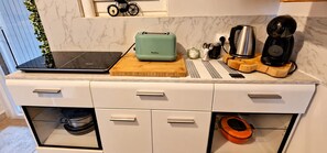 Eine Küche mit Laptop, Toaster, Kaffeemaschine und einem kleinen Fahrrad auf der Arbeitsfläche.