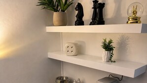 Une cuisine compacte avec un plan de travail noir, une machine à café, un grille-pain et une petite plante en pot.