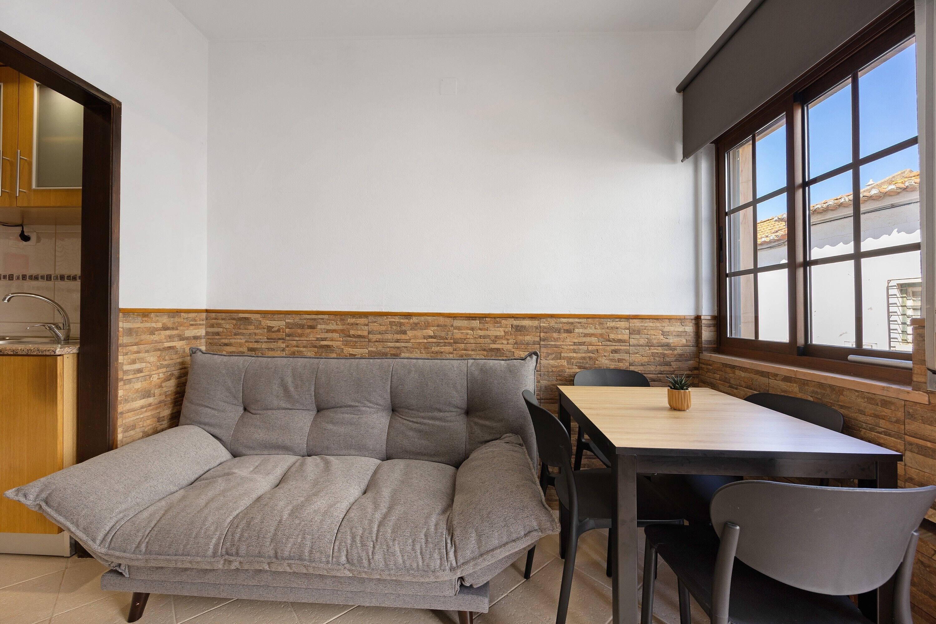 Een knus woongedeelte met een bank, een eettafel en stoelen.