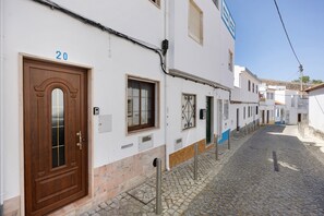 A narrow cobblestone street lined with white buildings, each with a wooden door and numbered windows. - Tiny Home 'Escadaria' with Sea View, Balcony and Wi-Fi (Lagos)