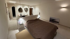 Una camera da letto moderna con un letto grande, una toeletta con specchi e un quadro appeso al muro.
