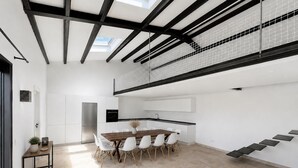 Una cucina moderna con isola centrale, mobili bianchi e piano di lavoro nero.
