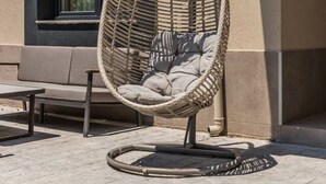 A wicker chair with cushions outside a building. - Loen Modern Seaside 3BR Apartment by PikHost (Durrës)
