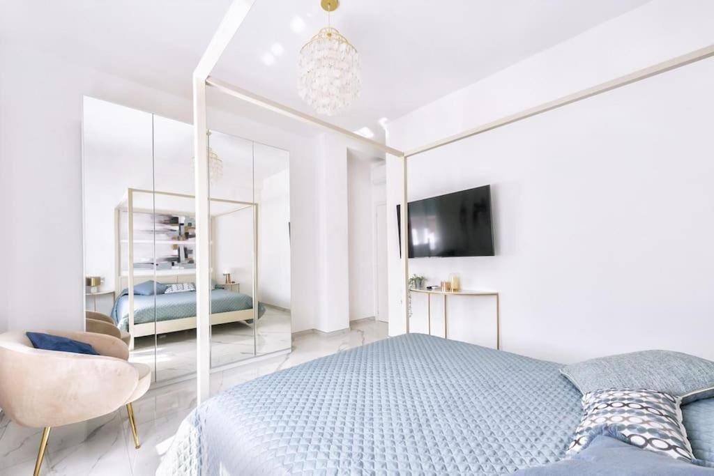 Una camera da letto moderna con un letto grande, una televisione e un separé in vetro.
