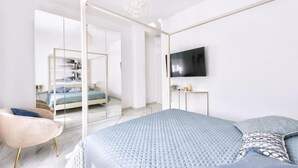 Un dormitorio moderno con una cama grande, televisión y separador de vidrio.