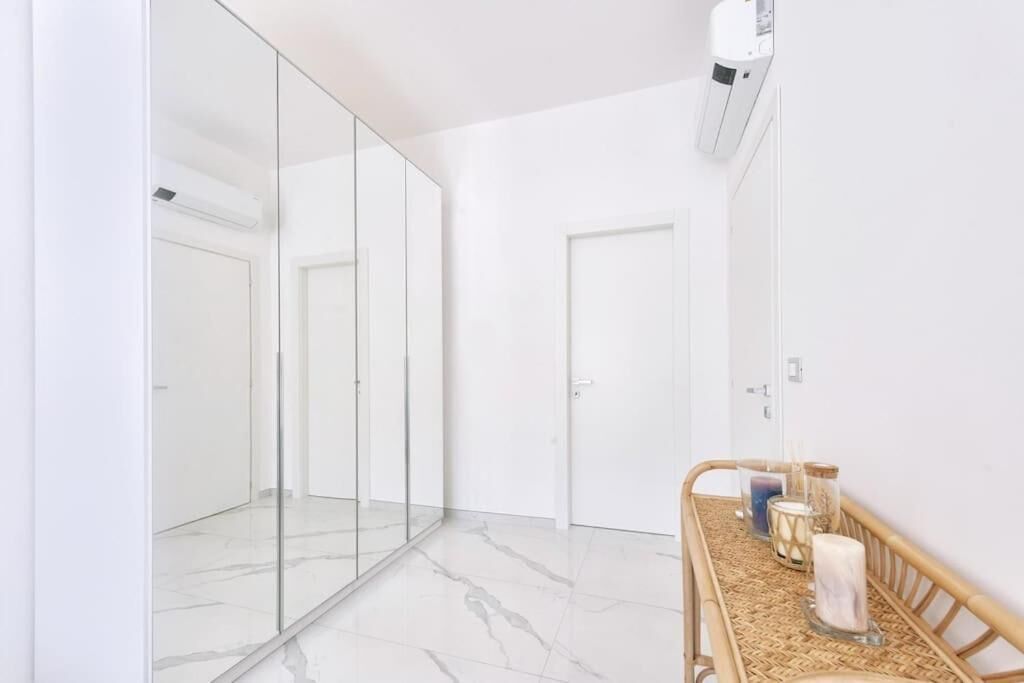 Un bagno moderno con cabina doccia in vetro, mobile bagno in legno e specchio.