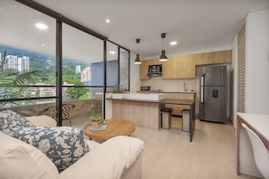 Une cuisine moderne équipée d’un réfrigérateur, d’un four à micro-ondes et d’un évier. Un coin repas avec une table et des chaises est également disponible.