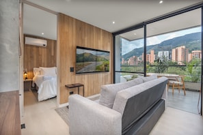 Une chambre à coucher moderne avec un lit, une table de chevet et un téléviseur fixé au mur.