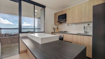 Una cucina moderna con un'isola grande, mobili in legno e vista sulla città.