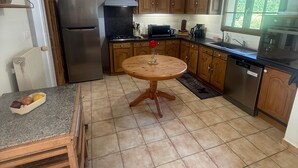 Una cocina con armarios de madera, un refrigerador de acero inoxidable, un microondas y un lavavajillas.