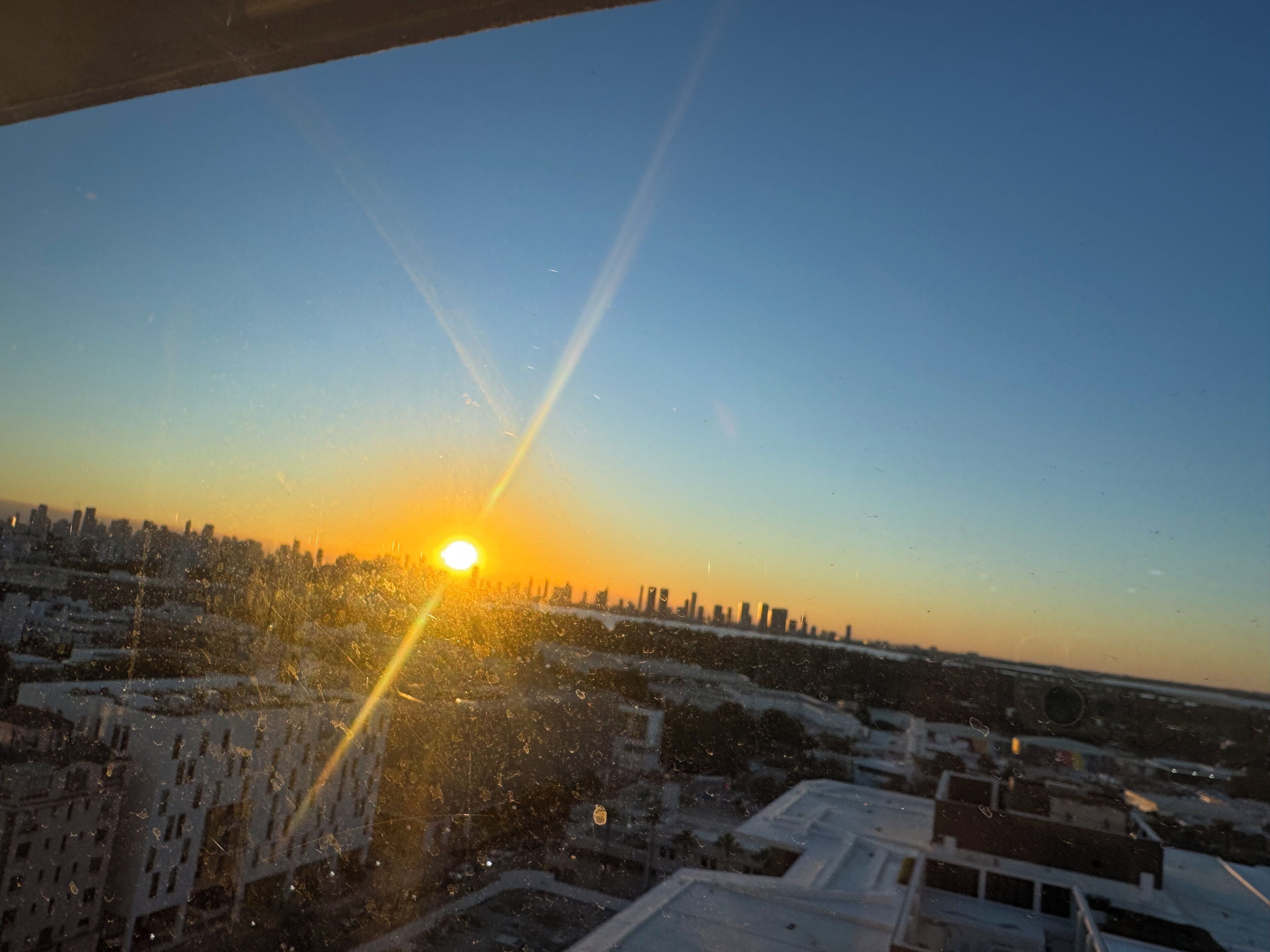 Un horizonte urbano al atardecer, con edificios y cielo despejado.