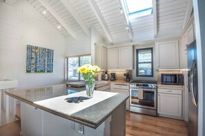 A modern kitchen with white cabinetry, a granite countertop, a stainless steel oven, and a microwave. - Snow Creek Comfort -2 Bedroom + Loft -outdoor pool (Sun Valley)
