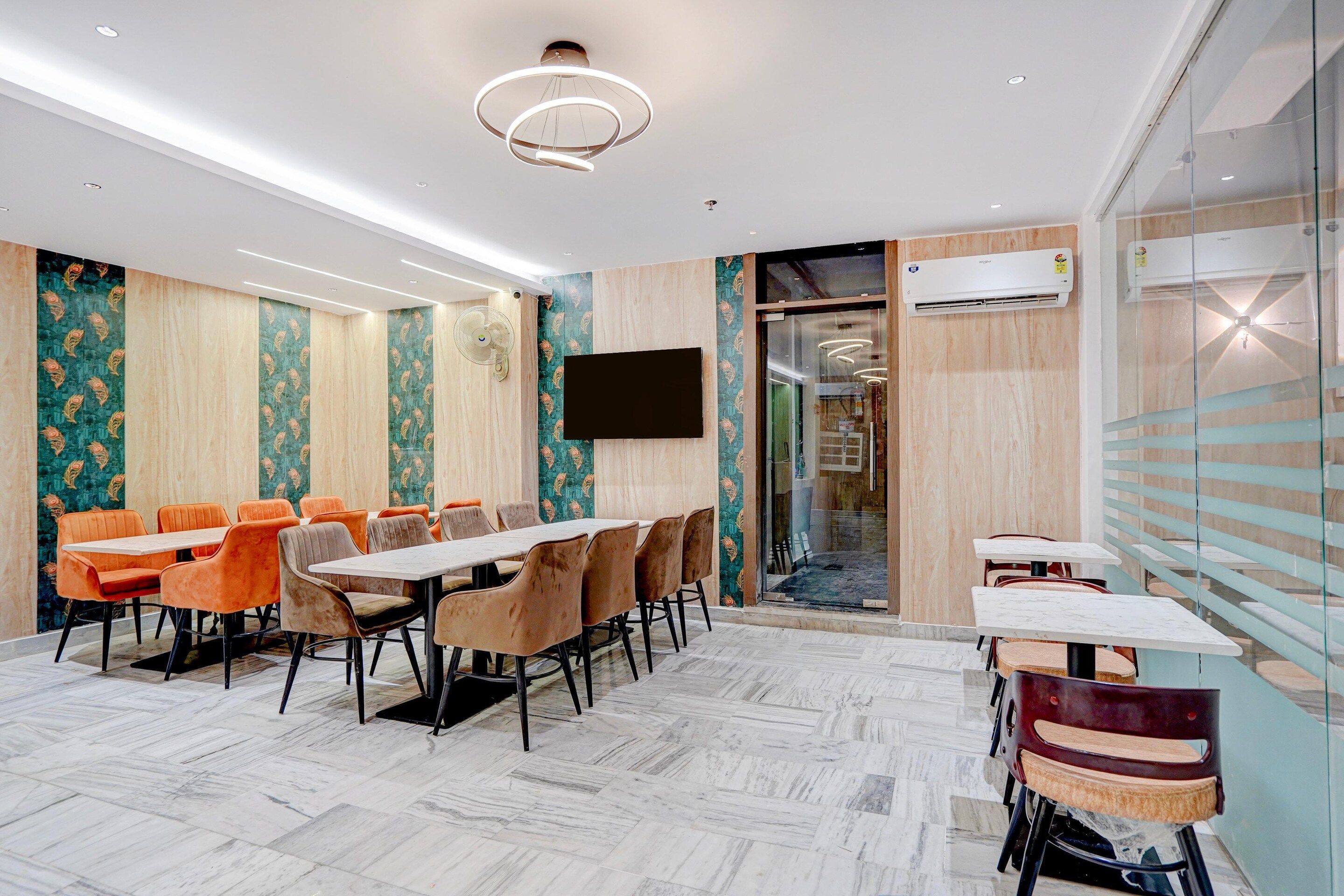 A conference room with a long table and chairs, a flat-screen TV, and an air conditioning unit.