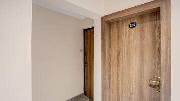 A wooden door with a brass handle and a number plate marked '207'.